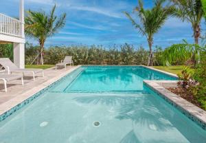 a swimming pool with palm trees and a villa at Mastway House -Pool & Dock! in Key West