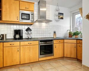 eine Küche mit Holzschränken und Küchengeräten aus Edelstahl in der Unterkunft Landhaus Residenz Ostsee Meeresbrise in Insel Poel