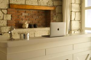 a laptop sitting on a counter in a brick wall at Aleysim Alaçatı-Design Als in Alaçatı
