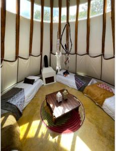 a room with two beds and a table in a yurt at Aldea Tipi: El Molino de Aldebarán in Villa de Leyva