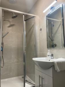 a bathroom with a shower and a sink at Cille Apartments, Ballyferriter village in Ballyferriter