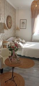 a bedroom with two beds and a table with a plant at La Lucques Masabelle in Mirepeisset
