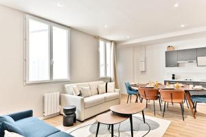a living room with a couch and a table at Appartement spacieux à 5 minutes de la capitale in Bagnolet