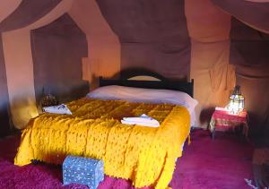 Sahara Berber Camp في زاكورة: غرفة نوم بسرير كبير في خيمة
