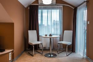 een kamer met een tafel, 2 stoelen en een raam bij Sienna Apartments in Skopje