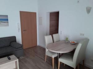 a living room with a table and chairs and a couch at Zentrale Wohnung in der Villa Liewald mit Terrasse und Glasfaseranschluss in Norderney +19 photos