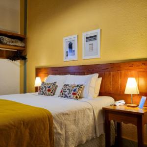 a bedroom with a bed with two lamps and a phone at Pouso 22 in Pirenópolis