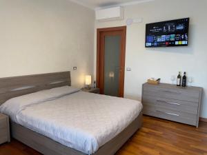 a bedroom with a bed and a tv on the wall at Landora in Grazzano Badoglio