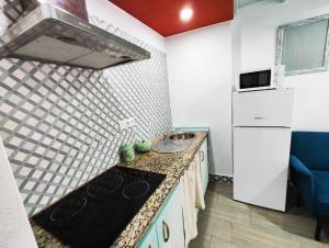 una piccola cucina con piano cottura e frigorifero di Apartamento PUERTA DE CÓRDOBA a Carmona