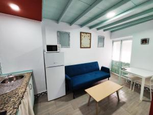 un soggiorno con divano blu e tavolo di Apartamento PUERTA DE CÓRDOBA a Carmona