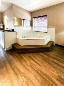 a large bathroom with a tub and a wooden floor at Prestige Aberdeen Lodge Kamloops in Kamloops