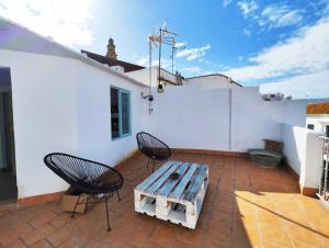 un patio con 2 sedie e un tavolo in legno di Apartamento PUERTA DE CÓRDOBA a Carmona