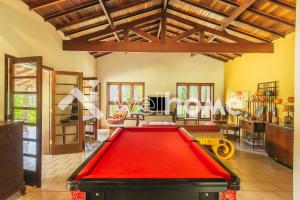 uma sala de estar com uma mesa de bilhar vermelha em Sítio com piscina e churrasqueira em Indaiatuba em Campinas