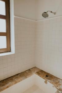 a bathroom with a bath tub with a window at Hotel Casa De Quino in Querétaro