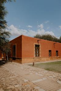 un bâtiment en briques rouges avec des fenêtres latérales dans l'établissement Hotel Casa De Quino, à Querétaro