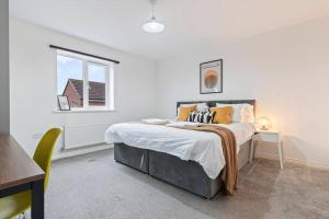 una camera bianca con un letto e una finestra di Anglian Retreat - Close to City Centre - Free Parking, Fast Wifi and Smart TV by Yoko Property a Coventry