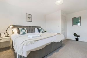 a white bedroom with a large bed and a desk at Anglian Retreat - Close to City Centre - Free Parking, Fast Wifi and Smart TV by Yoko Property in Coventry