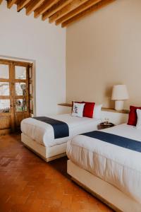 1 dormitorio con 2 camas y ventana en Hotel Casa De Quino en Querétaro