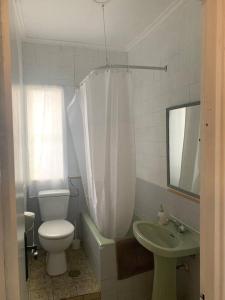 a bathroom with a toilet and a sink and a mirror at Piso amplio en pleno centro in Santander