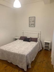 a bedroom with a white bed with two tables at Piso amplio en pleno centro in Santander