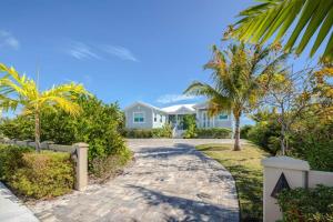 una casa blanca con palmeras y un camino de entrada en Coastal Chic by Brightwild-Pool & Boat Dock en Stock Island