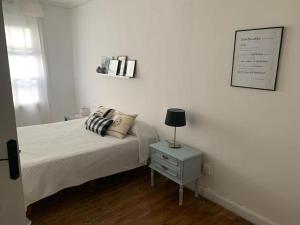 a bedroom with a bed and a table with a lamp at Piso amplio en pleno centro in Santander