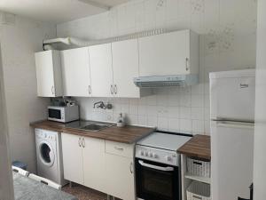 a kitchen with white cabinets and a washer and dryer at Piso amplio en pleno centro in Santander