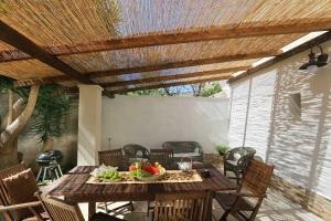 a wooden table with a bowl of fruit on a patio at Corte Antica 2 in Presicce