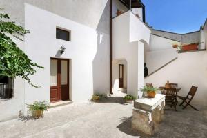 a courtyard of a white house with a table and chairs at Corte Antica 2 in Presicce