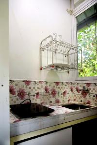brudną kuchnię ze zlewem i oknem w obiekcie vattachalil villa w mieście Anachal