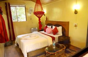 a bedroom with a large bed with red pillows at vattachalil villa in Anachal