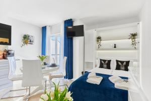 una camera con letto blu e una sala da pranzo di Golden Hour Apartments- Plac Słowiański 43 a Świnoujście