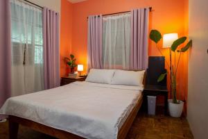 una camera da letto con un grande letto con pareti arancioni di Villa Raya w Outdoor Cinema, Bonfire, Treehouse & Parking a Vigan