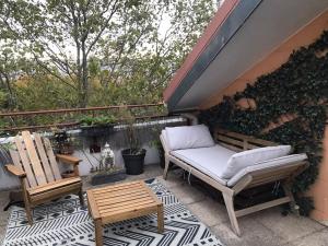 een patio met 2 stoelen en een bank op een patio bij T3 au cœur du village olympique in Saint-Denis