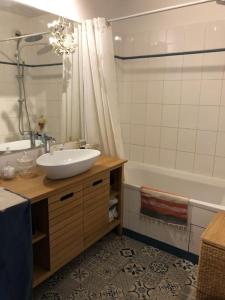 een badkamer met een wastafel en een bad met een wastafel bij T3 au cœur du village olympique in Saint-Denis