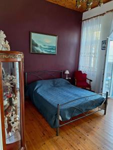 1 dormitorio con cama y pared púrpura en Gyzi 's house, en Tinos
