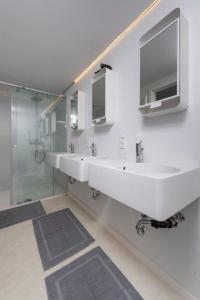 a bathroom with two sinks and a glass shower at Chez RG in Bruges