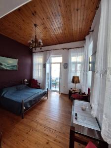 1 dormitorio con cama y techo de madera en Gyzi 's house, en Tinos