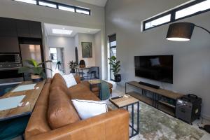 a living room with a couch and a flat screen tv at Luxurious Upmarket Apartment in Pretoria