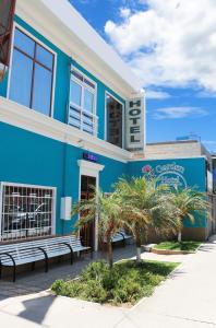 a blue building with benches in front of it at Hotel Garden Wilson in Iquique