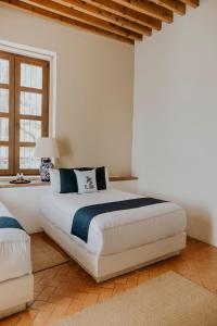 a bedroom with a large white bed and a window at Hotel Casa De Quino in Querétaro