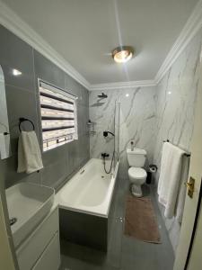 a bathroom with a white tub and a toilet at Ditoro Boutique Hotel in Pretoria