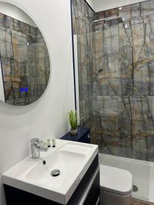 a bathroom with a white sink and a shower at New Sandpiper Apartments in Fleetwood