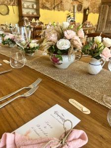 a table with flowers in vases on top of it at Agriturismo Il Campagnino in Cremona