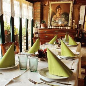 una mesa con servilletas verdes encima. en Agriturismo Il Campagnino, en Cremona