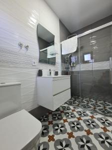 La salle de bains est pourvue de toilettes, d'un lavabo et d'une douche. dans l'établissement Къща за гости Софаш, 