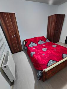 Schlafzimmer mit einem Bett mit einer roten Bettdecke in der Unterkunft Konak in Kragujevac