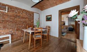 een eetkamer met een bakstenen muur en een tafel en stoelen bij Apartamenty Nova na Krakowskiej No 4 in Bielsko-Biala
