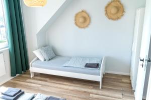 biały pokój z łóżkiem i zielonymi zasłonami w obiekcie Domki Przystań Kotwica w Jastrzębiej Górze