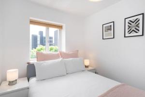 biała sypialnia z białym łóżkiem i oknem w obiekcie Omega - 3BD Gem in De Beauvoir Town w Londynie